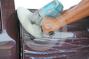 Automotive paint technician using grinder machine with wax on side of pickup , A part of the procedure to make a new color car