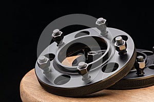 Automotive parts - close up new stainless black metal remote adapter spacer wheel hub of the car on black background