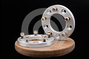 Automotive parts - close up new stainless metal remote adapter spacer wheel hub of the car on black background