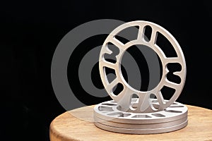 Automotive parts - close up new stainless metal remote adapter spacer wheel hub of the car on black background