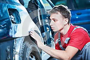 Automotive repair. mechanic puttying car body
