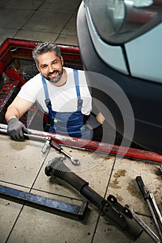 Automotive service technician posing for camera before fixing automobile