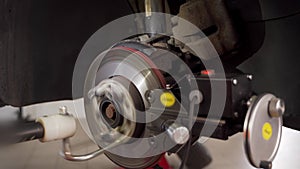 Automotive technician operates car brake disc lathe machine for precision rotor machining and skimming in garage