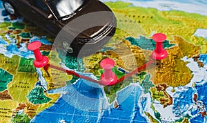 Automotive Travel Destination Points on World Map Indicated with Colorful Thumbtacks, Rope and Shallow Depth of Field.