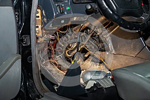 Automotive wiring under the wheel of an old German car, a disassembled dashboard for repairing and connecting electrical