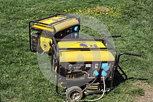 Autonomous portable yellow diesel generator stands on the grass