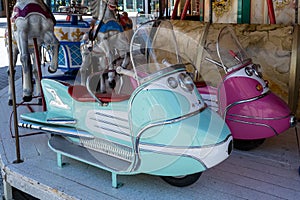 Autopede spacescooter in pink and turquoise on historical carousel, carrousel, roundabout, nostalig merry-go-round