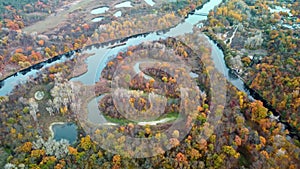 Autumn aerial look down on river with vivid forest