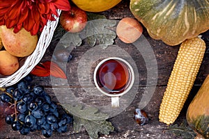 Autumn aesthetic rustic still life: fruits, vegetables and cup of tea: pumpkin, pears, apple, melon, grape and corn