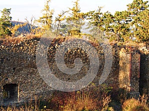 Autumn afternoon in the woods near the ruins of an old stone castle, sunny cold day, wild nature, adventure trip, travel