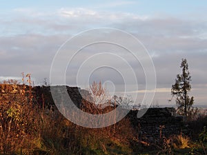 Autumn afternoon in the woods near the ruins of an old stone castle, sunny cold day, wild nature, adventure trip, travel