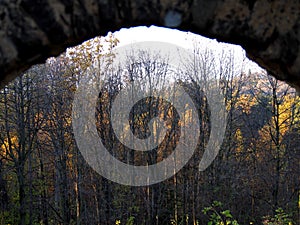 Autumn afternoon in the woods near the ruins of an old stone castle, sunny cold day, wild nature, adventure trip, travel