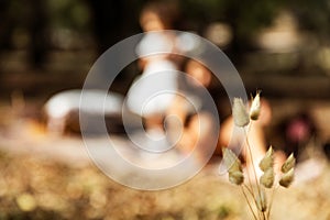 Autumn allusive image with dry leaf and children in blurred background