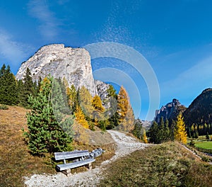 Autumn alpine Dolomites mountain scene and unrecognizable paragliders in sky, Selva di Val Gardena, Sudtirol, Italy