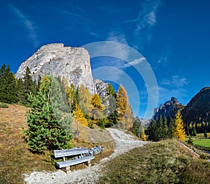 Autumn alpine Dolomites mountain scene and unrecognizable paragliders in sky, Selva di Val Gardena, Sudtirol, Italy