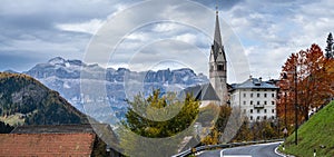 Autumn Dolomites village and old church, Livinallongo del Col di Lana, Italy photo