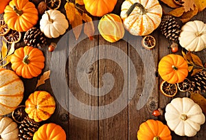 Autumn arch frame of pumpkins and natural fall decor on a rustic dark wood background