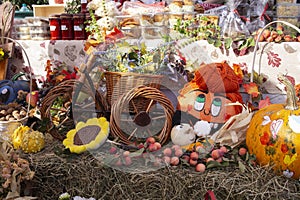 Autumn arrangement with painted pumpkin, fruits, vegetables, and flowers, at a market fair