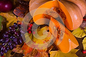 Autumn art composition - varied dried leaves, pumpkins, fruits, rowan berries on wooden background. Autumn, fall