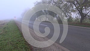 Autumn asphalt road with red truck and fog