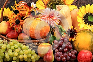 Autumn background with apples, pears, pumpkins, grapes, melons, sunflower flowers, plums in baskets on a wooden table,