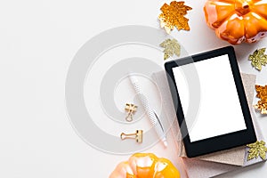 Autumn background with digital tablet ebook mockup, pumpkins, maple leaves on white table. Flat lay, top view