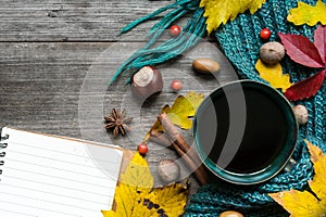 Autumn background with dry leaves, scarf, cup of coffee with spices and blank notebook