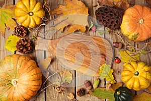 Autumn background with fall leaves and pumpkin over wooden table.