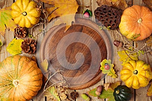 Autumn background with fall leaves and pumpkin over wooden table.