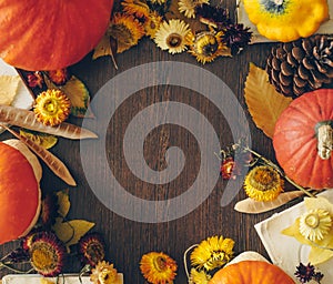 Autumn background with leaves and pumpkins. Frame of fall harvest on aged wood with copy space. Mockup for seasonal offers