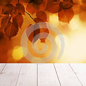 Autumn Background with Red Linden Leaves and Abstract Bokeh Glitter with empty white wooden board background