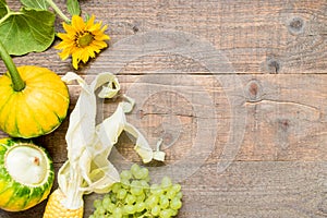 Autumn background with yellow leaves and vegetables. Frame of fall harvest on aged wood with copy space. top view and flat lay