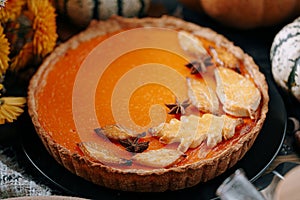 Autumn baking background with pumpkin pie pumpkin yellow autumn leaves on wooden background