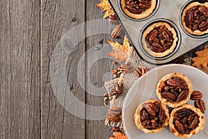 Autumn baking scene side border with pecan tarts over wood