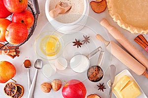 Autumn baking table scene with apple pie ingredients over a white marble