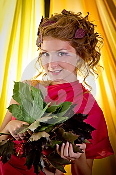 Autumn Beauty - fashion makeup with red autumn Leaves on girl's head