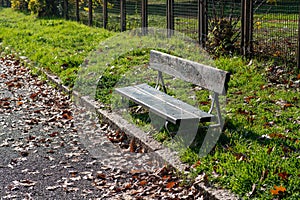 Autumn: a bench in a park with autumn leaves around, time of change of season with changes, silence and waiting