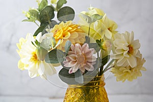Autumn bouquet with fresh dahlia flowers in yellow glass vase