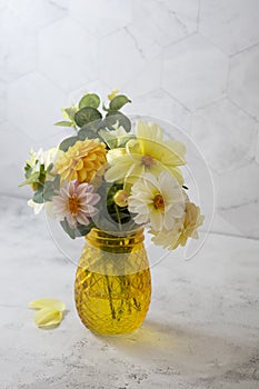 Autumn bouquet with fresh dahlia flowers in yellow glass vase