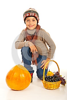 Autumn boy with pumpkin and grapes