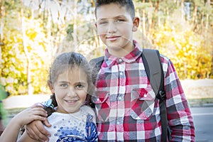 In the autumn  a brother hugs his sister