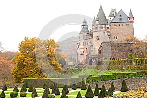 Autumn Burresheim Castle with topiary green trees in ornamental