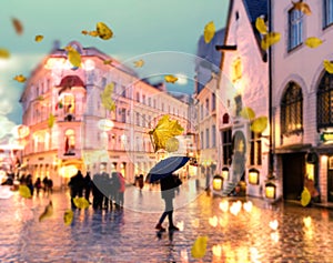 Autumn city blur ,man with blue umbrella,Rainy city evening people walking under umbrella evening Autumn leaves fall street in m