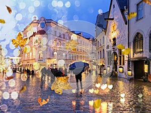 Autumn city blur ,man with blue umbrella,Rainy city evening people walking under umbrella evening Autumn leaves fall street in m