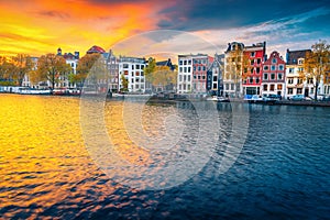 Autumn cityscape and water canal with houseboats in Amsterdam, Netherlands