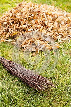 Autumn clearing - besom and a pile of leaves