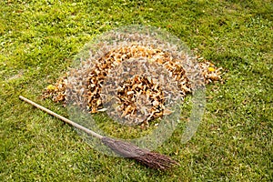 Autumn clearing - besom and a pile of leaves