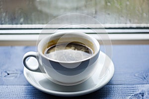 Autumn cloudy weather better with caffeine drink. Enjoying coffee on rainy day. Fresh brewed coffee in white cup or mug