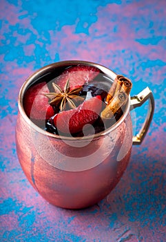 Autumn cocktail in copper mug with red plums