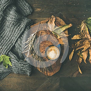 Autumn coffee concept with leaves and grey sweater, square crop